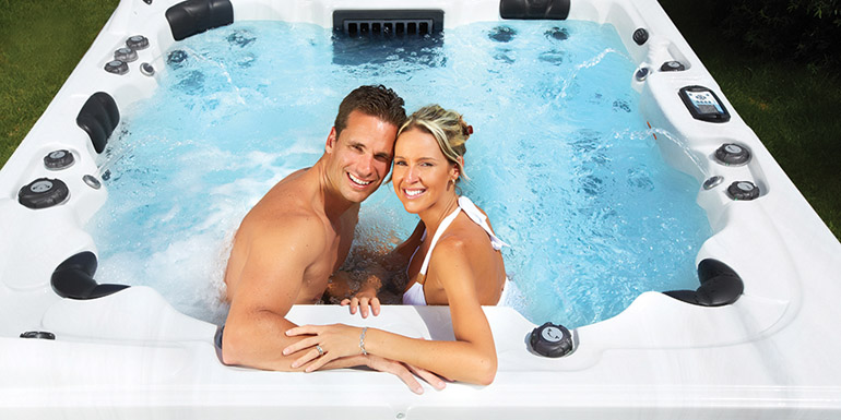 Happy couple relaxing in hot tub. Vacation.