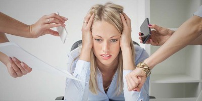 Depressed woman overloaded with stuff at work