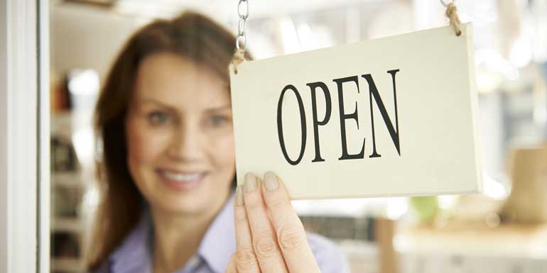 bigstock-store-owner-turning-open-sign-84316688