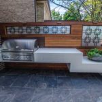 Large, sintered stone slab tiles surround the floating kitchenette.