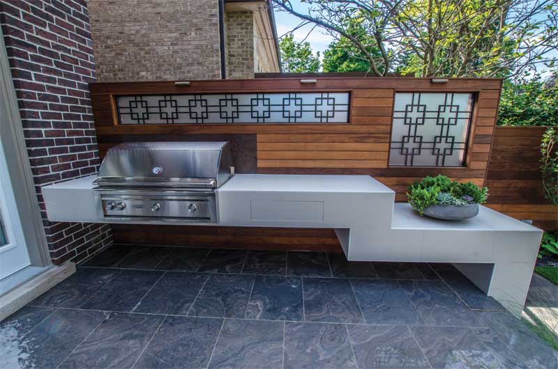 Large, sintered stone slab tiles surround the floating kitchenette.