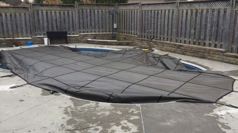 The first side straps across the pool’s width are installed.