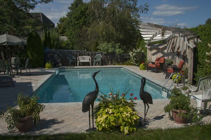 The ‘after’ photo shows an updated interlock concrete paver patio after this pool was renovated.