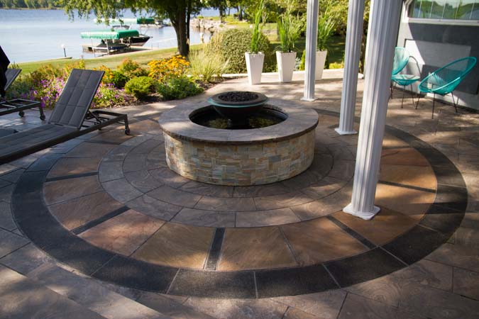 This fire/water feature surround has a circular design using multiple natural stone products. Each stone piece was hand cut and installed.