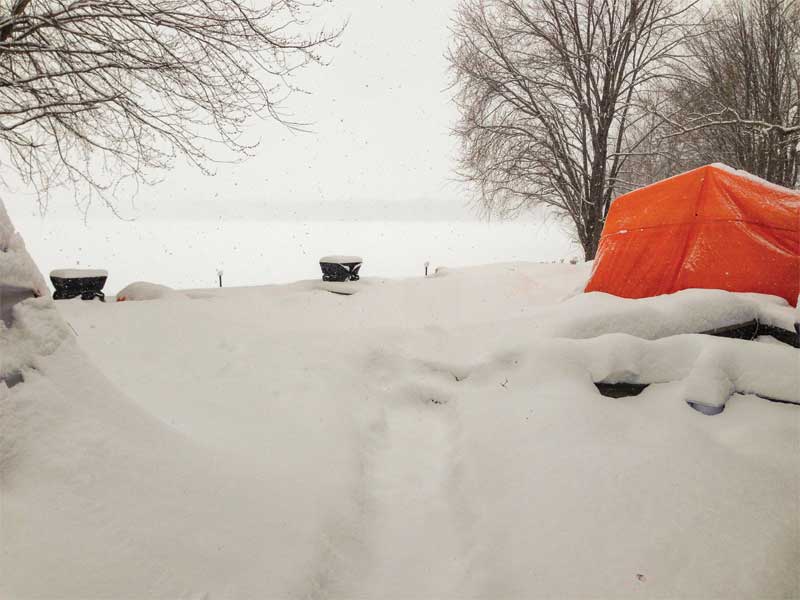 A concrete pool is buried under snow shortly after its tented enclosure has been removed.