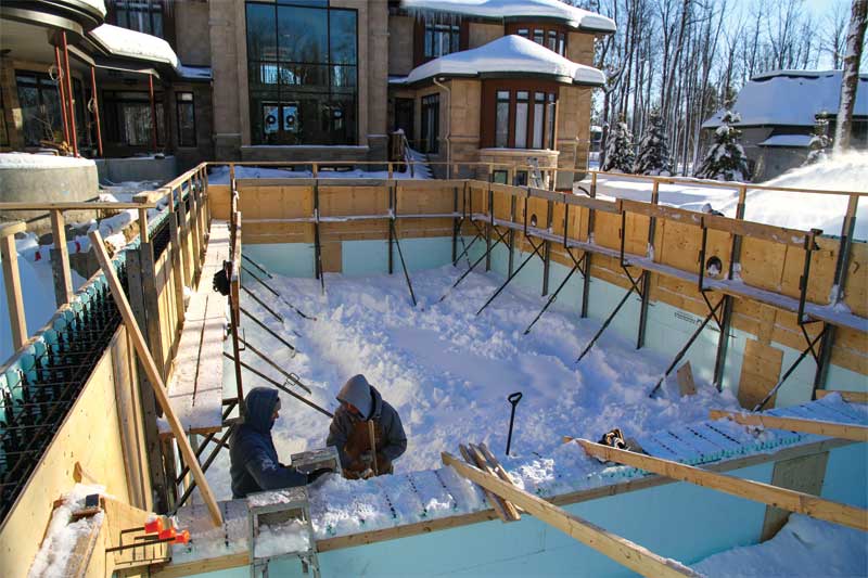 Workers brave the winter weather constructing this 7.3- x 15.2-m (24- x 50-ft) concrete pool.