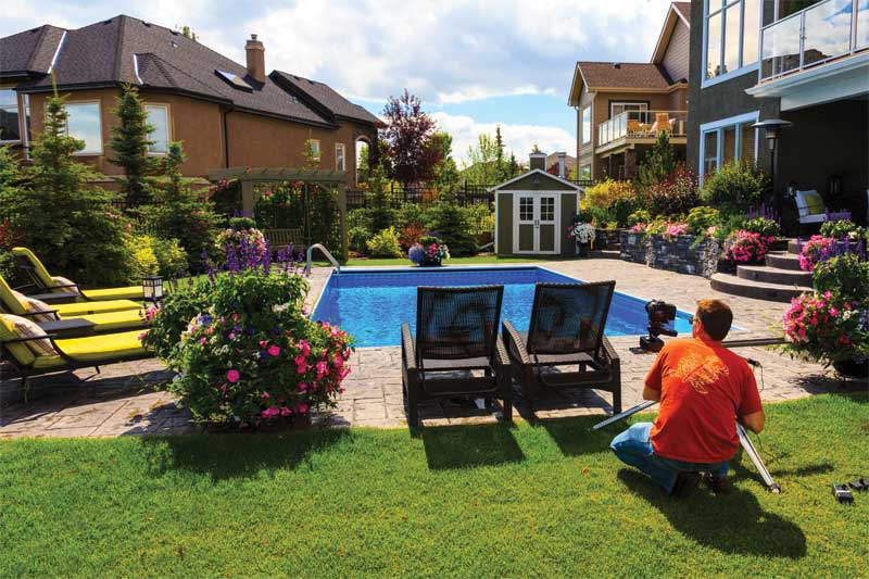 Setting up a slider track for a sliding time-lapse shot of a backyard pool and landscape project.