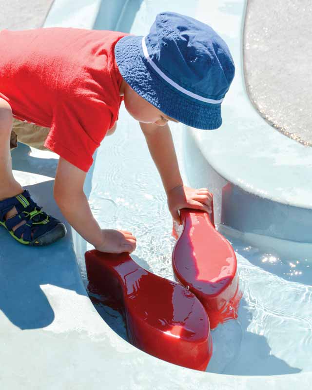 A discovery zone, featuring gentle spray textures, fascinating weirs, and meandering streams, provides a calm space for thoughtful play.