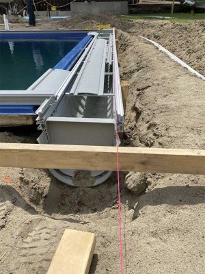 Before completing the backfilling of the pool, the automatic cover kit is attached at the deep end.