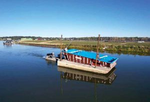 A barge was used to deliver five fibreglass pools to backyards located along a large reservoir in McCordsville, Indiana. 