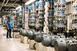 A service manager in a waterpark mechanical room, where the company was hired to make efficiency upgrades.