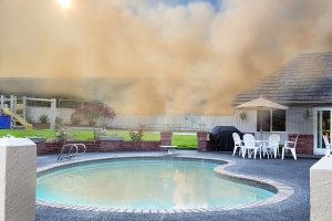 An image showing a plausible situation where a swimming pool is surrounded by wildfire smoke.