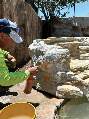 When applying the stain colour, it is essential to do so in a random fashion to avoid creating patterns that can make the artificial rock appear unrealistic.