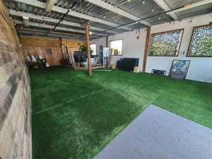 In the spring of 2020, synthetic grass was installed as flooring and wooden window frames and a wood accent wall was added at the front of the store.