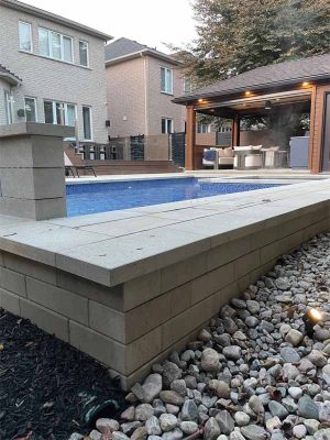 The company’s landscape and pool teams came together to construct a retaining wall within the pool over-dig, just outside the easement, with freeze protection.