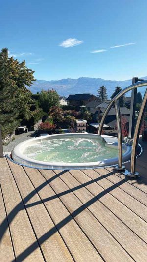 The prefabricated hot tub hovers in mid-air, gracefully lowered onto a custom-made landing. 