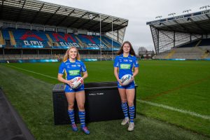 Rugby players from U.K.-based Leeds Rhinos pose standing in front of a "Chill Tub" by Chill Tubs.