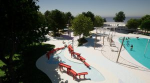 Rendering of a water park upgrade with red bridges, slides, and shaded pool areas.