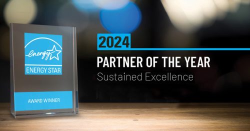 Energy Star 2024 Partner of the Year award on acrylic stand with blurred lights in the background.