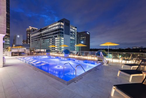 night view of a hotel with a well-lit swimming pool