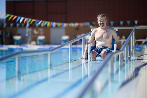 man on a wheelchair entering pool