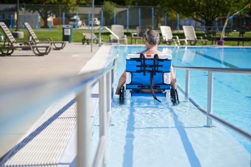 back shot of a man in a wheelchair trying to enter the pool