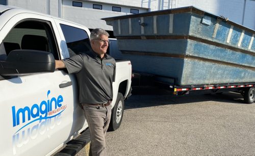 man standing in front of a truck, smiling