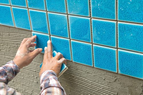 pool contractor adding tiles to a pool