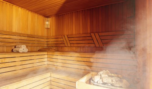 Interior of Finnish sauna, classic wooden sauna with hot steam. Russian bathroom. Relax in hot sauna with steam. Wooden interior baths, wooden benches and loungers accessories for sauna, spa complex