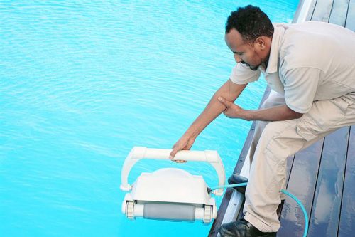 man holding a robotic pool cleaner