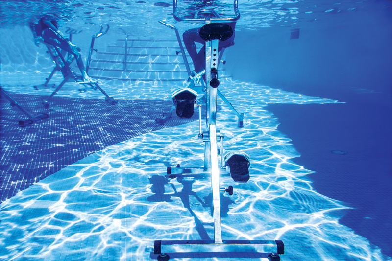 Underwater stationary bikes in a pool, exercise equipment. Aquatic therapy, aquatic workouts in blue water.